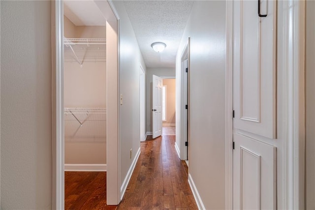 corridor featuring dark hardwood / wood-style flooring and a textured ceiling