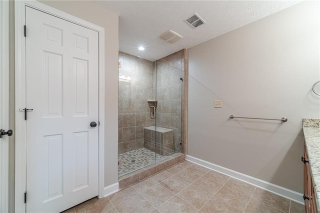 bathroom with an enclosed shower, vanity, and a textured ceiling