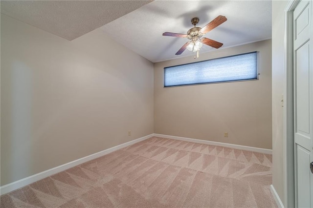 spare room featuring light carpet, ceiling fan, and a textured ceiling