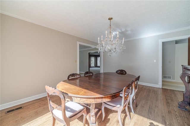 dining area with ornamental molding, a chandelier, and light wood-type flooring