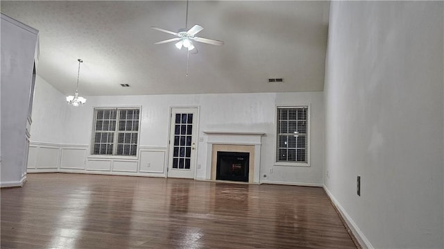 unfurnished living room with hardwood / wood-style flooring, lofted ceiling, and ceiling fan with notable chandelier