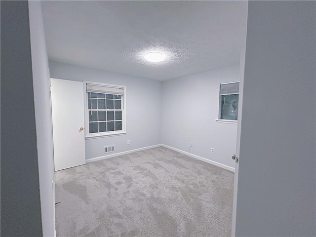 carpeted empty room featuring a textured ceiling