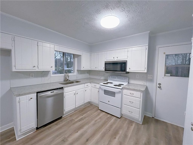 kitchen featuring stainless steel appliances, white cabinetry, sink, and a textured ceiling