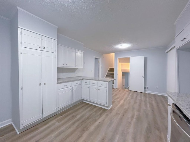 kitchen featuring dishwasher, light hardwood / wood-style floors, a textured ceiling, white cabinets, and kitchen peninsula