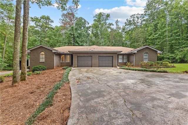 view of front of home with a garage, concrete driveway, and brick siding