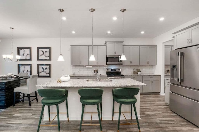 939 Brittfield Way, Loganville, GA 30052 - kitchen with appliances with stainless steel finishes, gray cabinetry, a kitchen breakfast bar, decorative backsplash, and recessed lighting