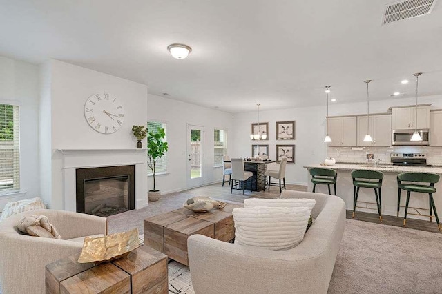 939 Brittfield Way, Loganville, GA 30052 - living area featuring plenty of natural light, a chandelier, a glass covered fireplace, and recessed lighting