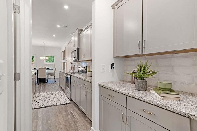939 Brittfield Way, Loganville, GA 30052 - kitchen featuring appliances with stainless steel finishes, light wood-style flooring, backsplash, recessed lighting, and gray cabinets
