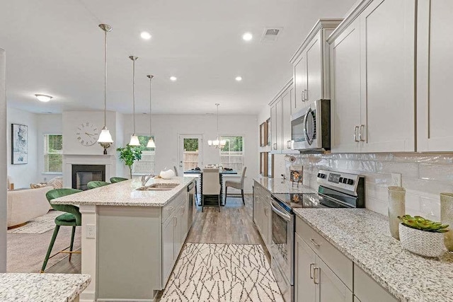 939 Brittfield Way, Loganville, GA 30052 - kitchen with stainless steel appliances, open floor plan, a breakfast bar, healthy amount of natural light, and recessed lighting