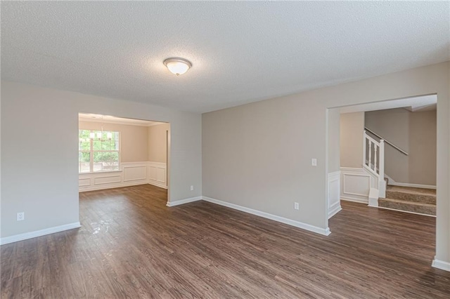 105 Kentwood Springs Dr, Hampton, GA 30228 - empty room featuring stairs, dark wood-style floors, an inviting chandelier, and a textured ceiling