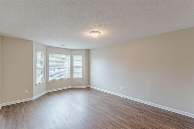 105 Kentwood Springs Dr, Hampton, GA 30228 - empty room with dark wood-style flooring, a textured ceiling, baseboards, and visible vents