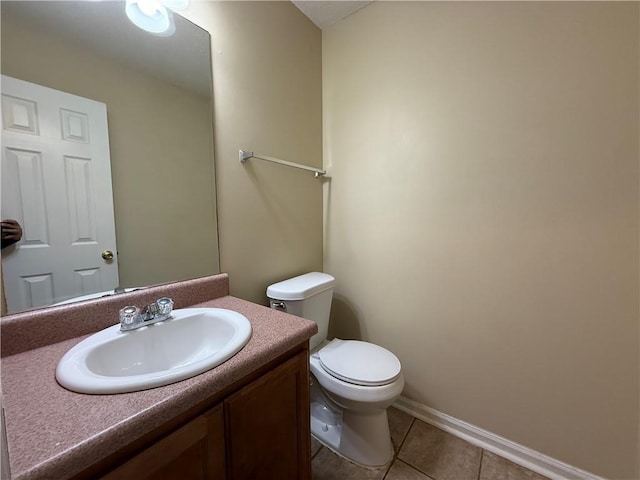 half bath featuring tile patterned flooring, toilet, vanity, and baseboards