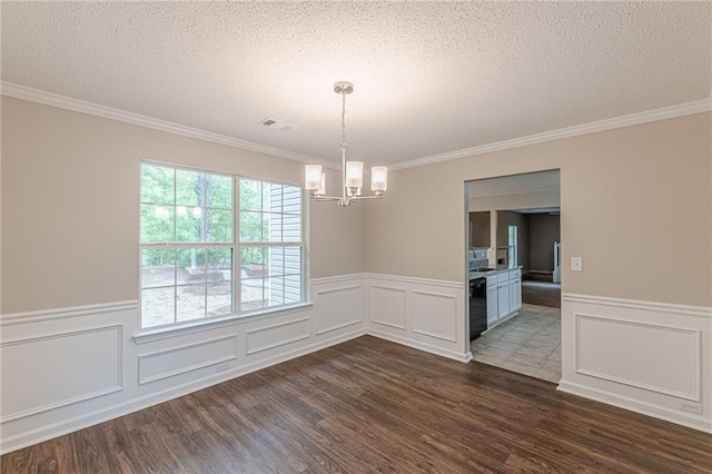 105 Kentwood Springs Dr, Hampton, GA 30228 - unfurnished dining area featuring a textured ceiling, wainscoting, a chandelier, crown molding, and dark wood-type flooring