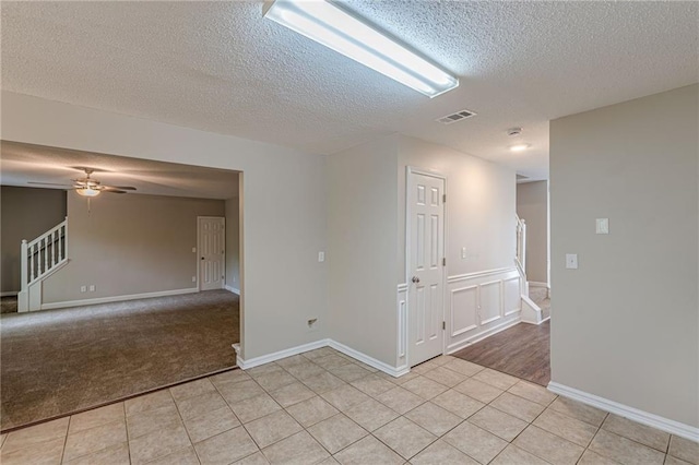 105 Kentwood Springs Dr, Hampton, GA 30228 - spare room with light tile patterned floors, a ceiling fan, a textured ceiling, visible vents, and stairway