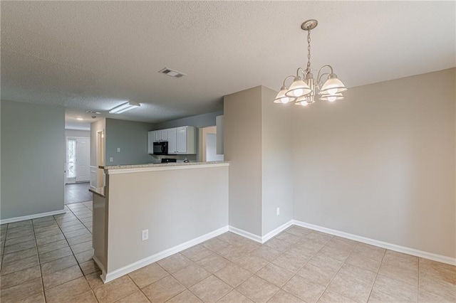 105 Kentwood Springs Dr, Hampton, GA 30228 - kitchen with a notable chandelier, a textured ceiling, light tile patterned floors, visible vents, and black microwave