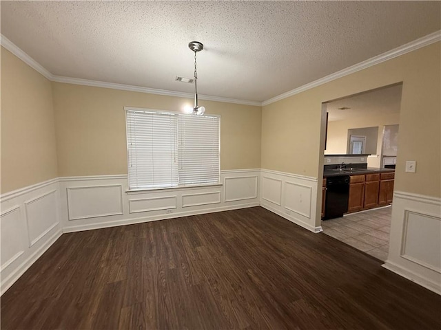 unfurnished dining area with a sink, dark wood-type flooring, crown molding, and a textured ceiling