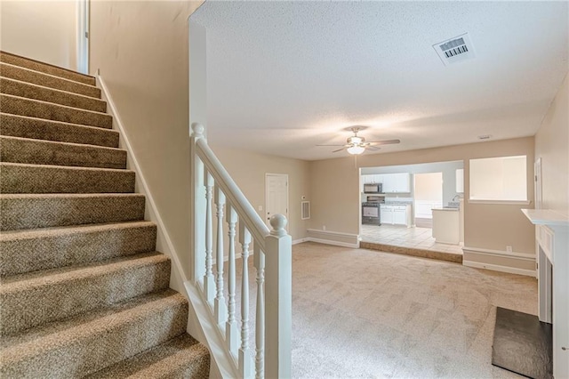 105 Kentwood Springs Dr, Hampton, GA 30228 - staircase with carpet floors, a textured ceiling, visible vents, baseboards, and ceiling fan
