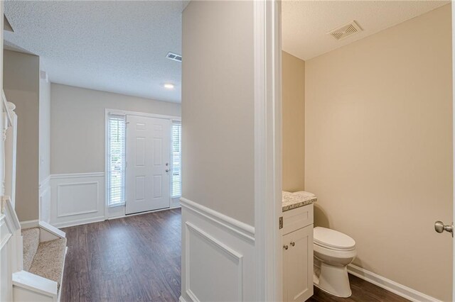 105 Kentwood Springs Dr, Hampton, GA 30228 - entrance foyer featuring a textured ceiling, visible vents, wainscoting, and dark wood-type flooring