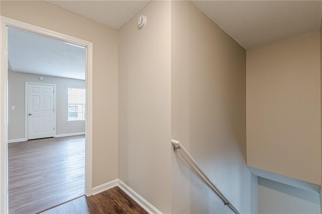 105 Kentwood Springs Dr, Hampton, GA 30228 - corridor featuring baseboards, an upstairs landing, a textured ceiling, and dark wood-type flooring