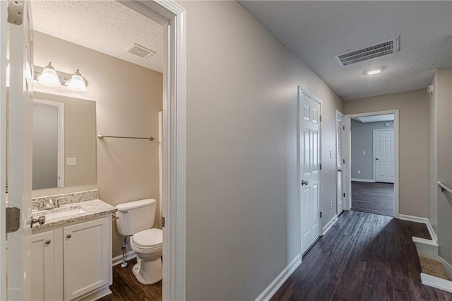 105 Kentwood Springs Dr, Hampton, GA 30228 - hall with dark wood finished floors, a sink, visible vents, and a textured ceiling
