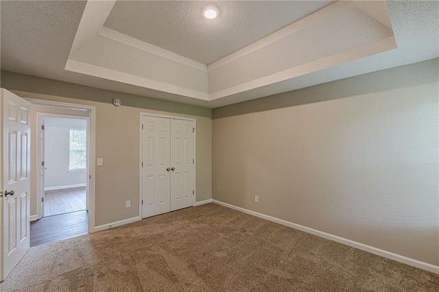 105 Kentwood Springs Dr, Hampton, GA 30228 - unfurnished bedroom featuring a closet, a textured ceiling, carpet floors, a tray ceiling, and baseboards