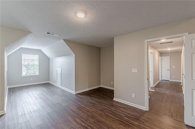105 Kentwood Springs Dr, Hampton, GA 30228 - additional living space featuring attic access, a textured ceiling, visible vents, and dark wood-style flooring