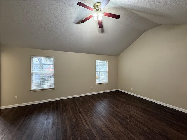 spare room with plenty of natural light, dark wood-type flooring, and vaulted ceiling