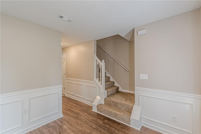 105 Kentwood Springs Dr, Hampton, GA 30228 - stairway with a decorative wall, wainscoting, visible vents, and wood finished floors