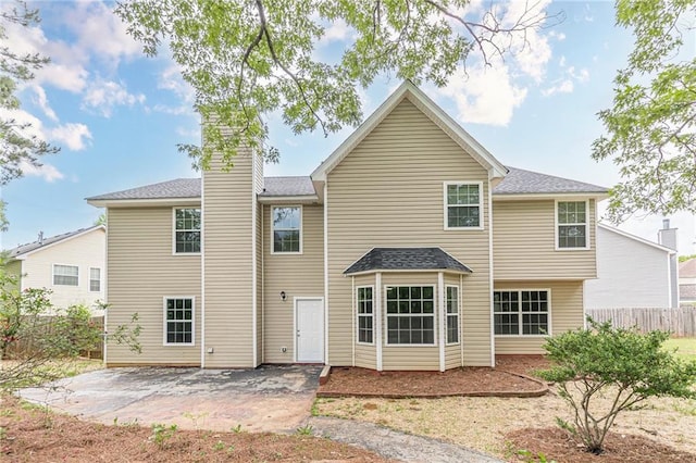 105 Kentwood Springs Dr, Hampton, GA 30228 - rear view of house featuring a chimney, a patio, roof with shingles, and fence