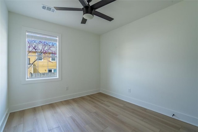 unfurnished room with visible vents, baseboards, ceiling fan, and wood finished floors