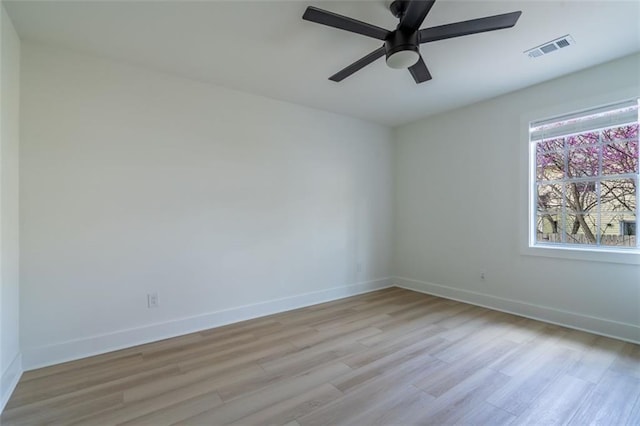 empty room with visible vents, light wood-style floors, and baseboards