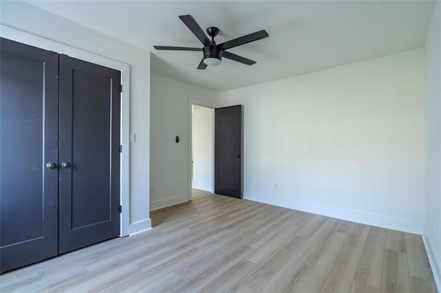 unfurnished bedroom with a ceiling fan, baseboards, light wood finished floors, and a closet