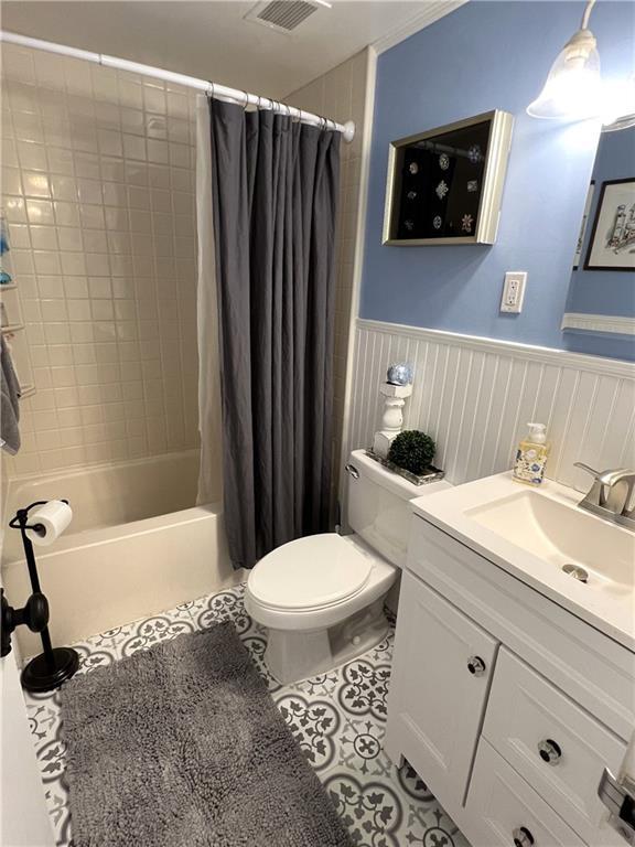 full bathroom featuring tile patterned floors, shower / tub combo with curtain, vanity, and toilet