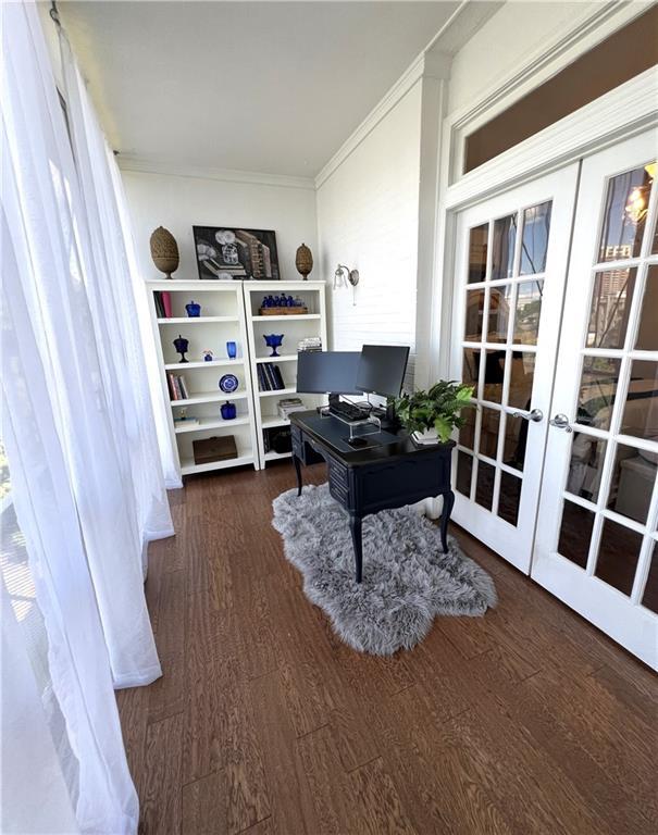 home office with crown molding, french doors, and dark wood-type flooring