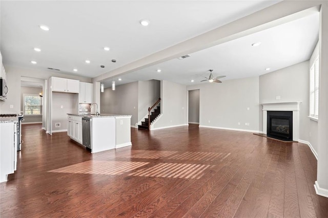 unfurnished living room with sink, dark hardwood / wood-style floors, and ceiling fan