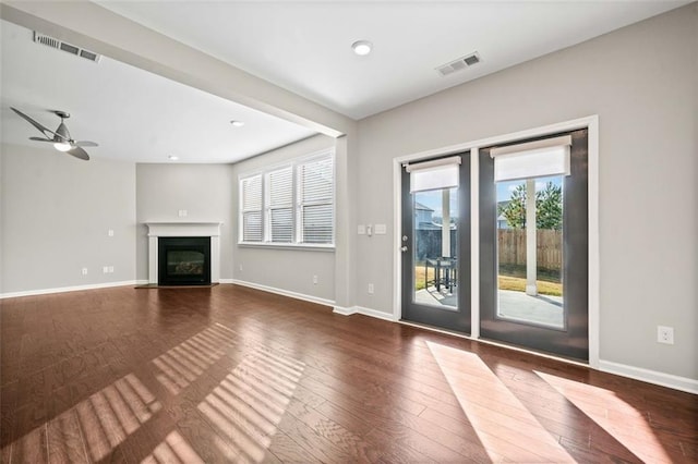 unfurnished living room with dark wood-type flooring and ceiling fan