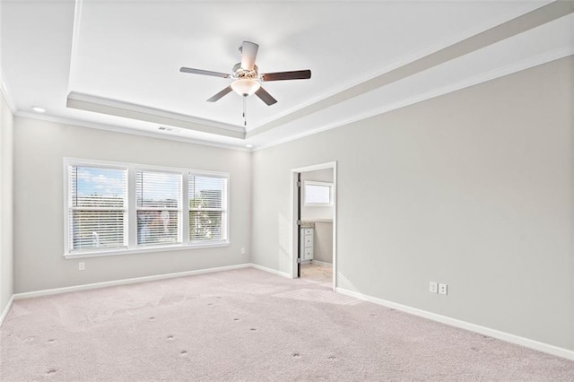 empty room with crown molding, light carpet, ceiling fan, and a tray ceiling