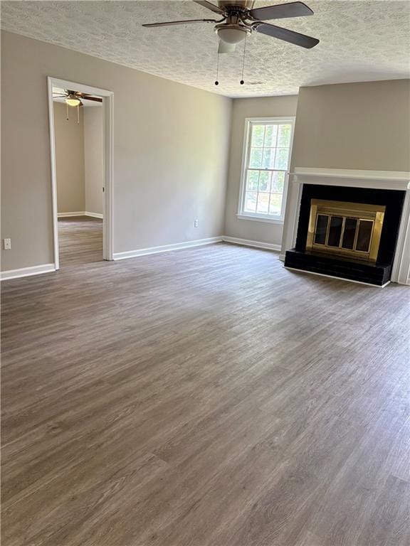 6103 Chaseland Dr, Rex, GA 30273 - unfurnished living room featuring a ceiling fan, a textured ceiling, wood finished floors, baseboards, and a glass covered fireplace