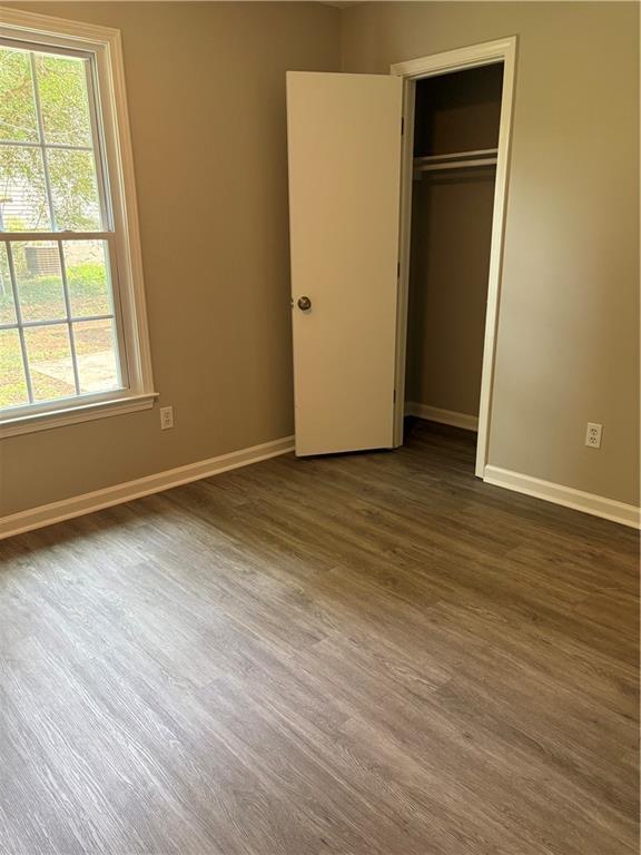 6103 Chaseland Dr, Rex, GA 30273 - unfurnished bedroom featuring baseboards, dark wood-style floors, and a closet