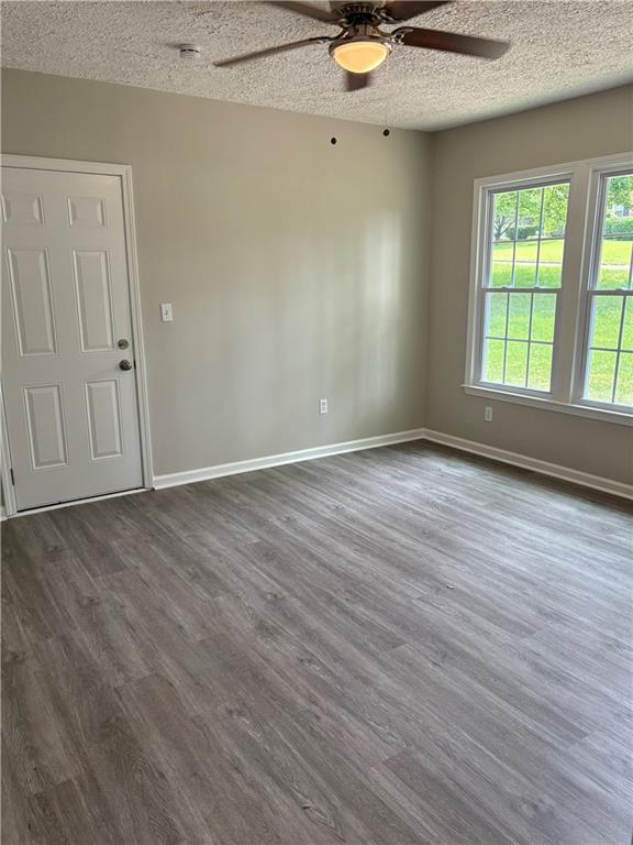 6103 Chaseland Dr, Rex, GA 30273 - unfurnished room featuring ceiling fan, dark wood-type flooring, baseboards, and a textured ceiling