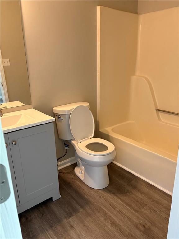 6103 Chaseland Dr, Rex, GA 30273 - full bath with wood finished floors, toilet, vanity, shower / bath combination, and baseboards