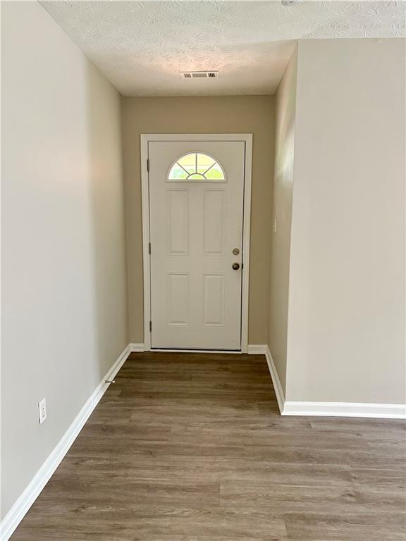 6103 Chaseland Dr, Rex, GA 30273 - entryway with a textured ceiling, wood finished floors, and baseboards