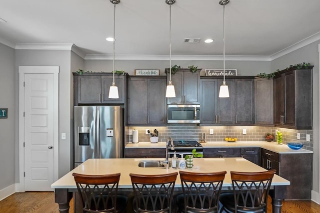 1976 Boyd Trace Ln NW, Atlanta, GA 30318 - kitchen featuring stainless steel appliances, an island with sink, crown molding, decorative backsplash, and a breakfast bar area