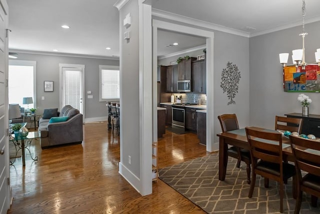 1976 Boyd Trace Ln NW, Atlanta, GA 30318 - dining space featuring a chandelier, dark wood finished floors, healthy amount of natural light, ornamental molding, and baseboards