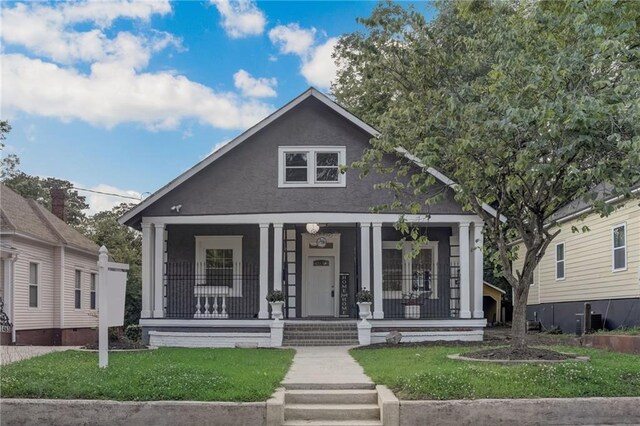 bungalow featuring a front lawn and covered porch