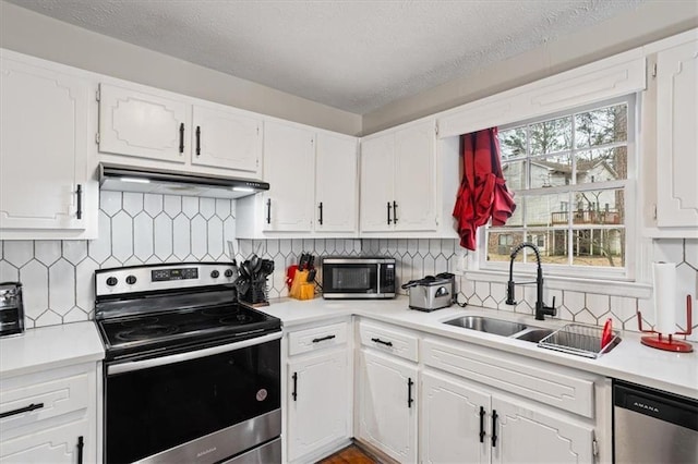 kitchen with sink, appliances with stainless steel finishes, a textured ceiling, white cabinets, and decorative backsplash