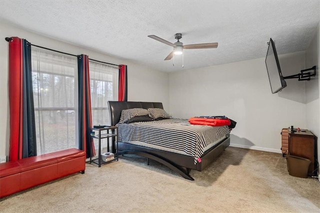 carpeted bedroom featuring ceiling fan and a textured ceiling