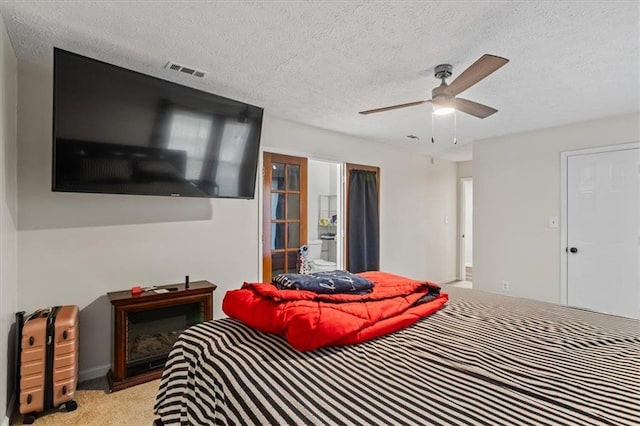 carpeted bedroom featuring ceiling fan and a textured ceiling