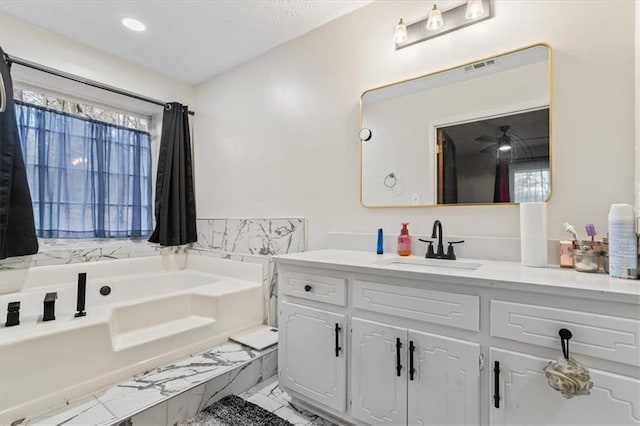 bathroom featuring vanity and a relaxing tiled tub