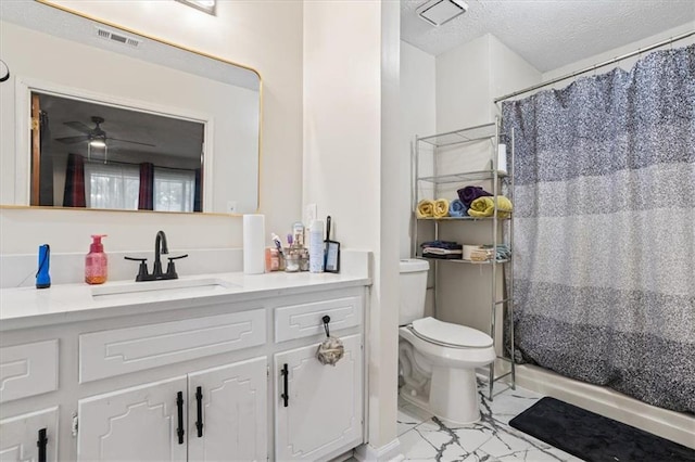 bathroom with ceiling fan, vanity, a textured ceiling, a shower with curtain, and toilet